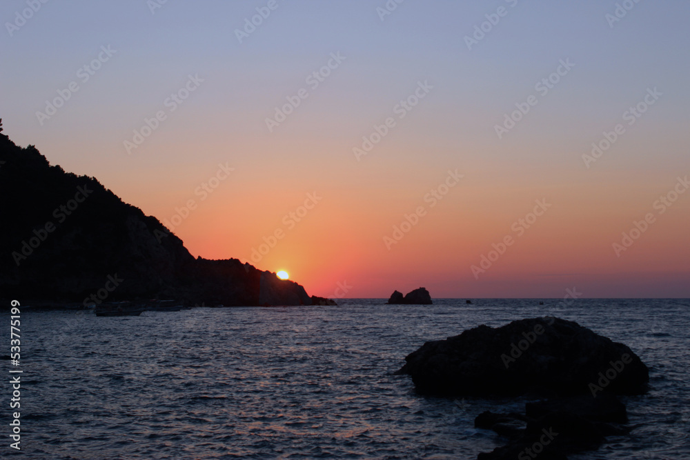 sunset over the sea with shore cliff 