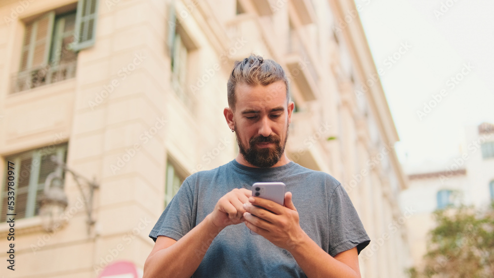 Young man with beard uses map application on mobile phone
