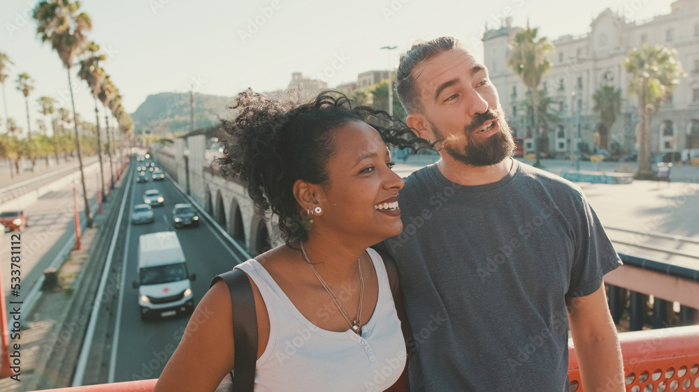 Close-up of happy interracial couple talking while standing on bridge Close-up of happy interracial couple talking while standing on bridge
