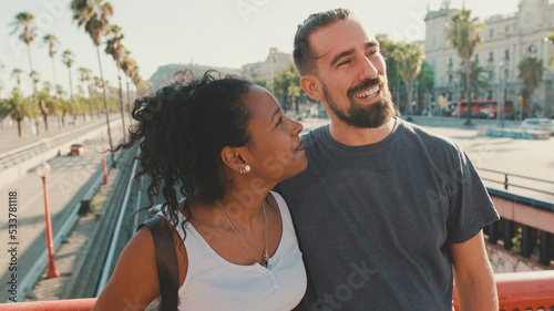 Close-up of happy interracial couple talking while standing on bridge