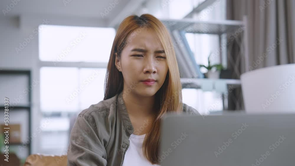 Young Asian woman overworked and exhausted experiences headaches and vision issues after using a laptop for work. Young Asian woman overworked and exhausted experiences headaches and vision issues after using a laptop for work.