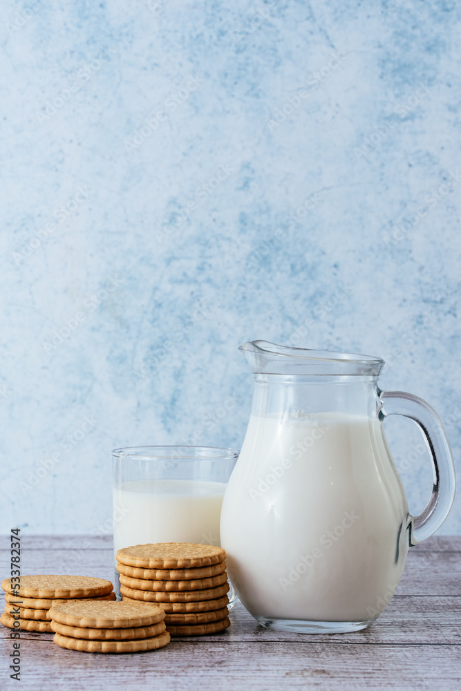 milk in a decanter and a glass with cookies milk in a decanter and a glass with cookies