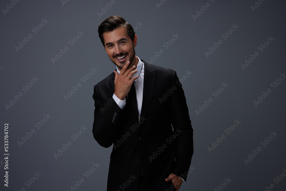 Man businessman smiling happily with his teeth raised hands up in a business suit with tie on a dark gray background Man businessman smiling happily with his teeth raised hands up in a business suit with tie on a dark gray background