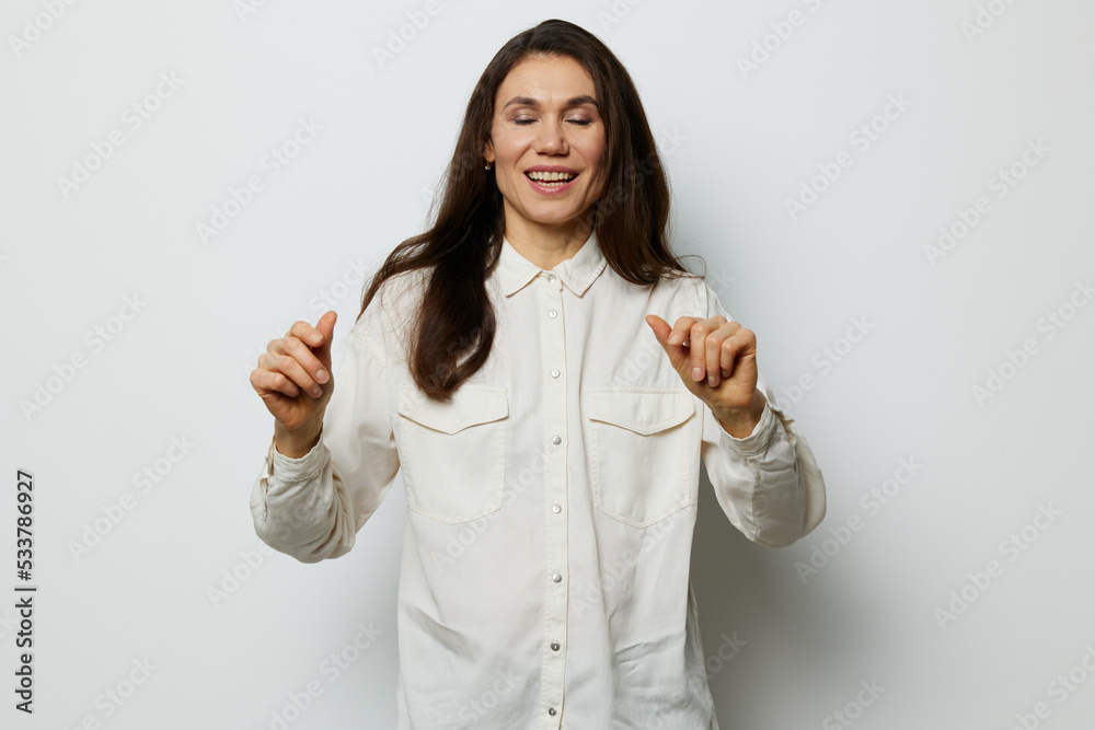 portrait of a beautiful happy woman on a white background with an empty space standing with her eyes closed and a wide smile in a white shirt portrait of a beautiful happy woman on a white background with an empty space standing with her eyes closed and a wide smile in a white shirt