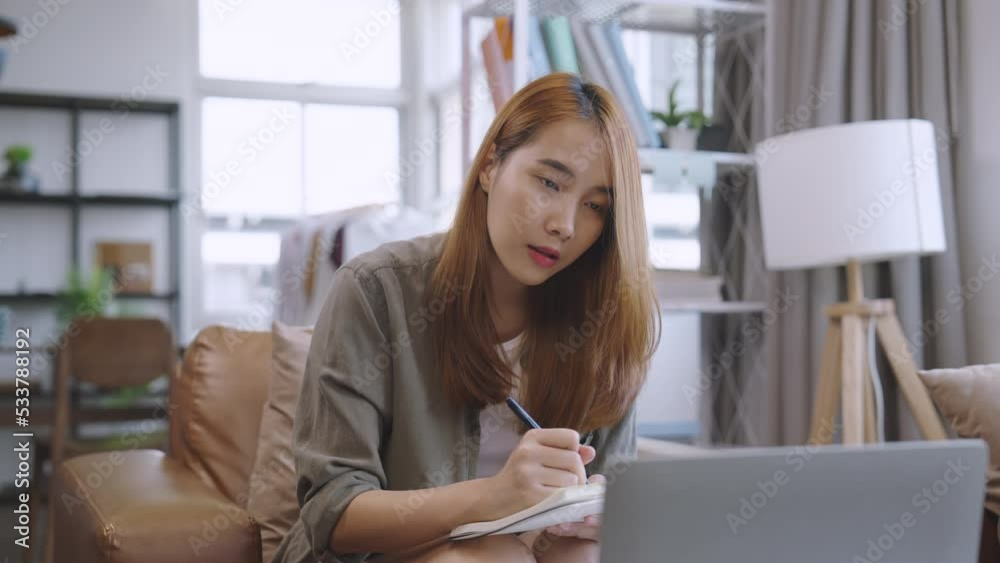 Young asian female take a summary of information from an online class or meeting business seminar.
