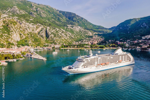 Luxury passenger liner in the bay of Kotor with travel returning after the Covid 19 pandemic Portrait of a disgruntled girl sitting at a cafe table