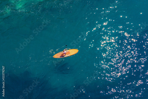 Young women Having Fun Stand Up Paddling in blue water sea in Montenegro. SUP. girl Training on Paddle Board near the rocks Portrait of a disgruntled girl sitting at a cafe table