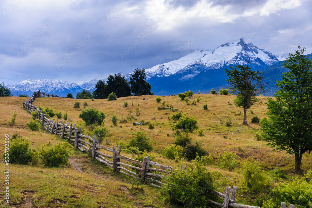 Chile, Aysen, Rio Colonia. Wooden fence in grazing landscape.