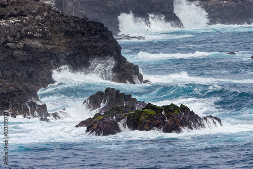 Waves crashing over lava rocks on shoreline of Espanola Island, Galapagos Islands, Ecuador.