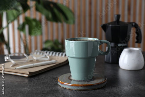 Fototapeta Naklejka Na Ścianę i Meble -  Mug of hot drink with stylish cup coaster on grey table