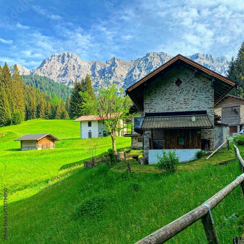 Resort houses in the mountain valley of Trentino with the Alps background, Italy photo