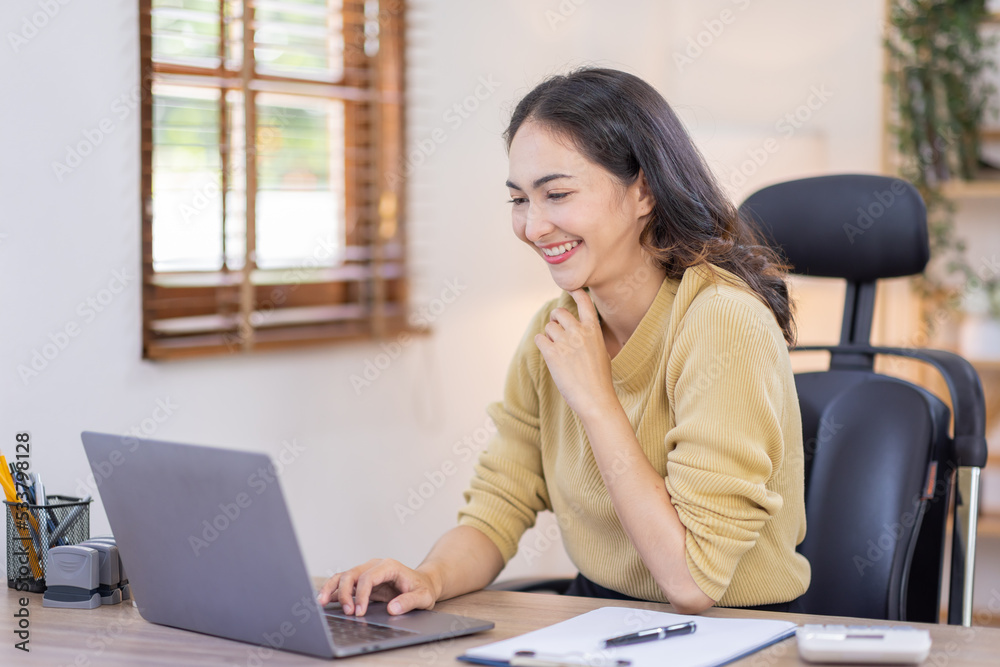 Smiling indian woman using laptop at home, Happy Young asian businesswoman send email and working at home. Asian freelancer typing on computer with paperworks and documents on table. Smiling indian woman using laptop at home, Happy Young asian businesswoman send email and working at home. Asian freelancer typing on computer with paperworks and documents on table.