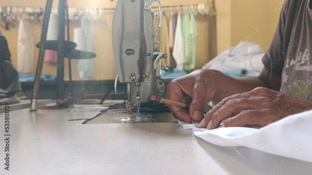 Top view of an elderly Latin woman doing an embroidery with a sewing machine in a sewing workshop in Granada Nicaragua Top view of an elderly Latin woman doing an embroidery with a sewing machine in a sewing workshop in Granada Nicaragua