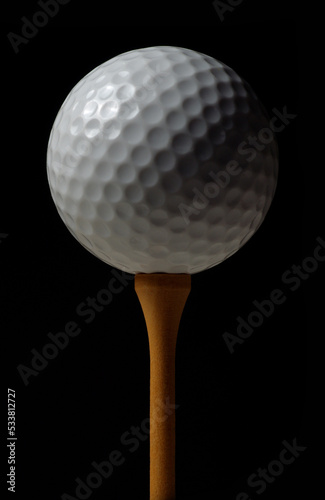 golf ball on tee on black color background