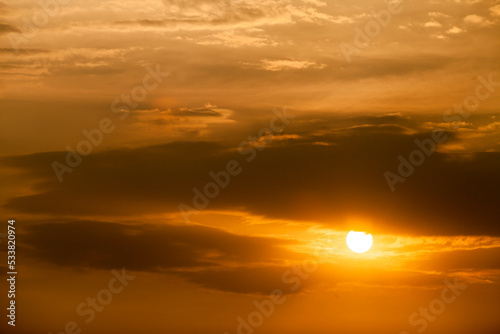 Telephoto photo of yellow orange sunset sunrise  clouds  sky golden hour. golden