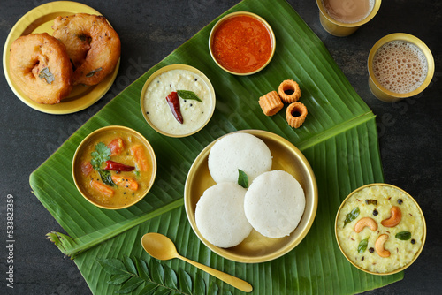 Many Idli or idly popular breakfast of Kerala South India and Sri Lanka. Banana leaf healthy steamed rice cakes by steaming fermented batter of black lentils and rice coconut chutney tomato chutney. photo