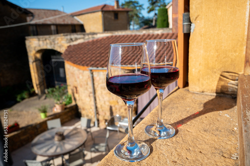 Tasting of red wine by old wine maker in Pierres Dorées region with yellow stone houses on south of Beaujolais region, France photo