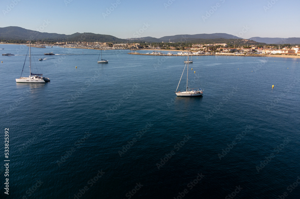 Aerial view on Gulf of Saint-Tropez, sail boats, houses of Port Grimaud and Port Cogolin, summer vacation in Provence, France