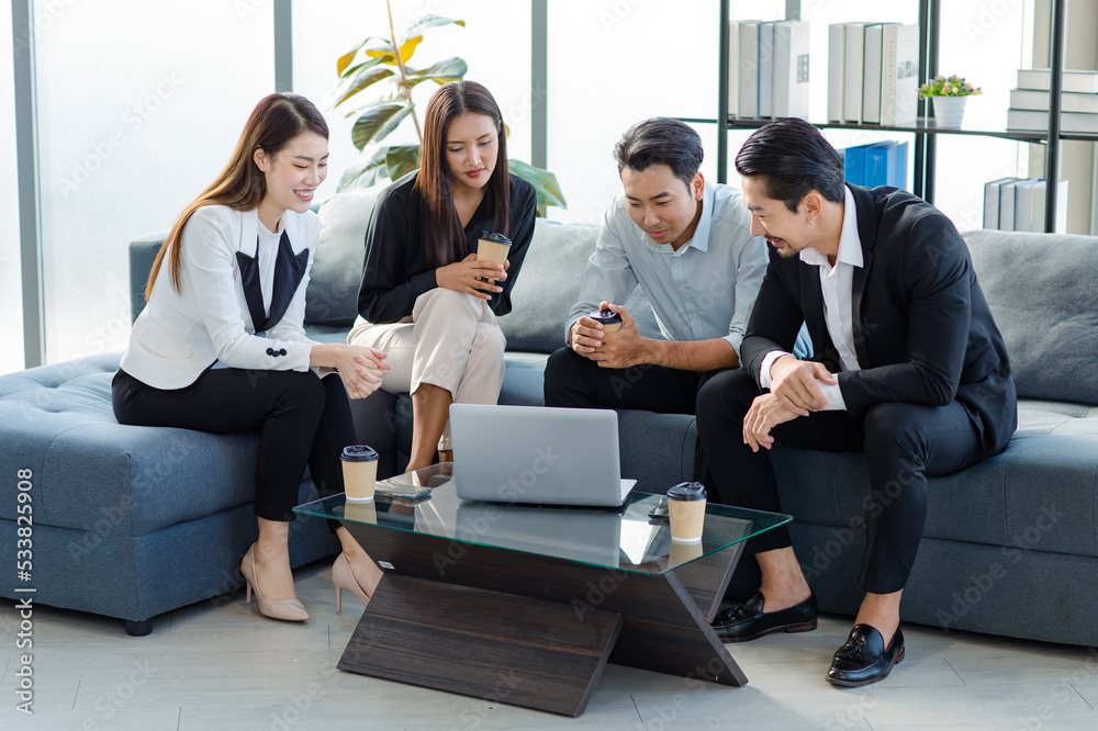 Group of millennial Asian young happy male female businessman businesswoman employee staff in formal business suit sitting on sofa smiling discussing brainstorming talking together in office. Group of millennial Asian young happy male female businessman businesswoman employee staff in formal business suit sitting on sofa smiling discussing brainstorming talking together in office.