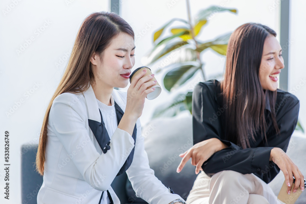 Group of millennial Asian young happy male female businessman businesswoman employee staff in formal business suit sitting on sofa smiling discussing brainstorming talking together in office. Group of millennial Asian young happy male female businessman businesswoman employee staff in formal business suit sitting on sofa smiling discussing brainstorming talking together in office.