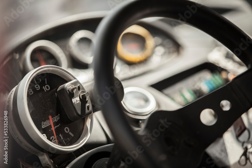 Rally car dashboard gauges and steering wheel close up macro, switches © Giuseppe