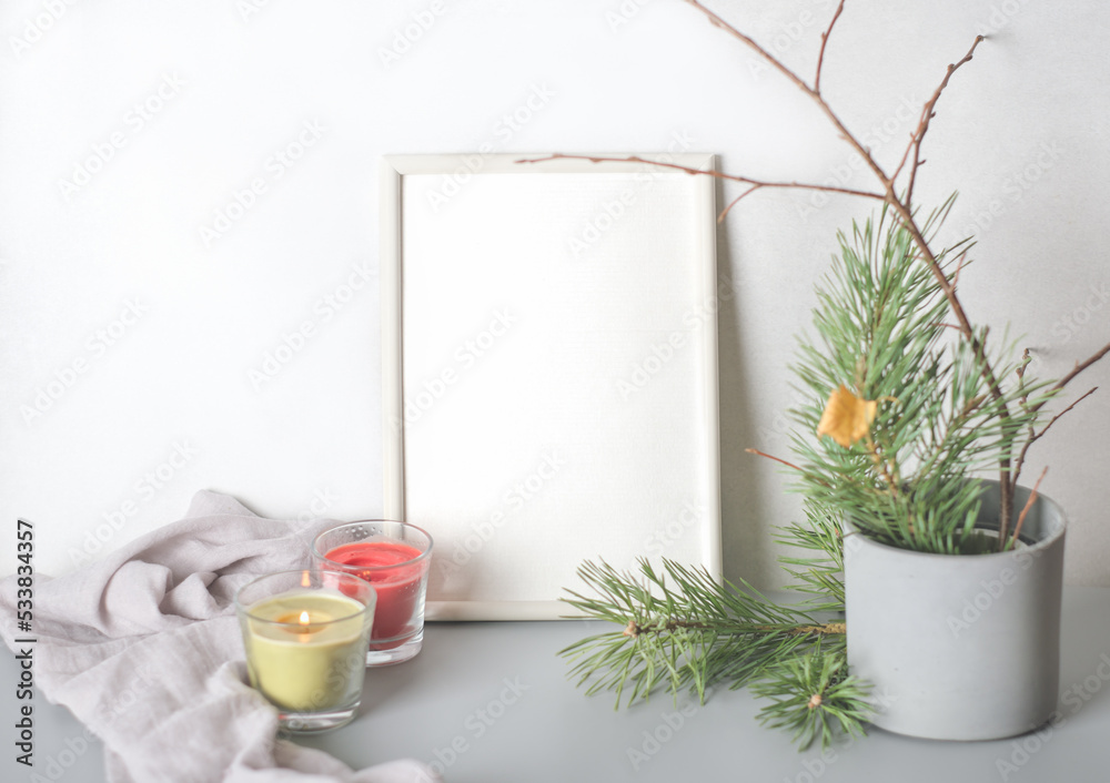 empty frame with copy space. winter still life with glowing candles and pine tree branches in cement flowerpot. place for inspirational text. winter season mood.