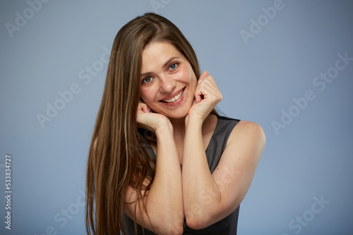 Smiling woman with long hair leaned on hands isolated portrait on blue background