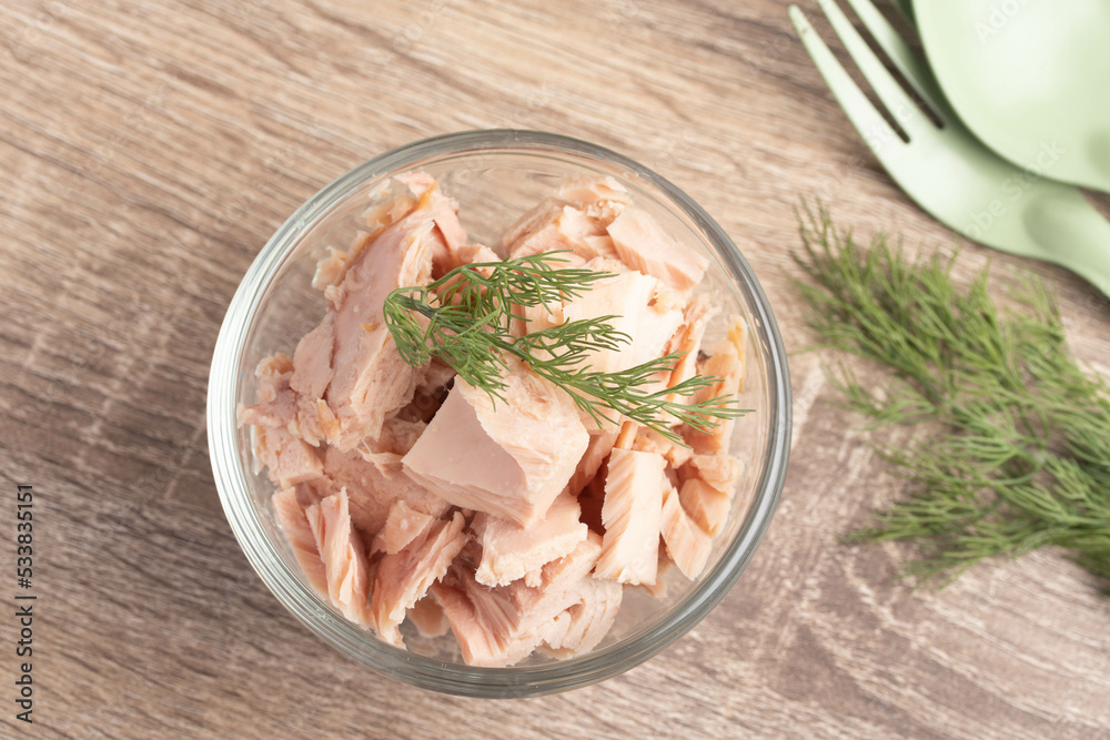 canned tuna in a clear glass cup on wooden background canned tuna in a clear glass cup on wooden background