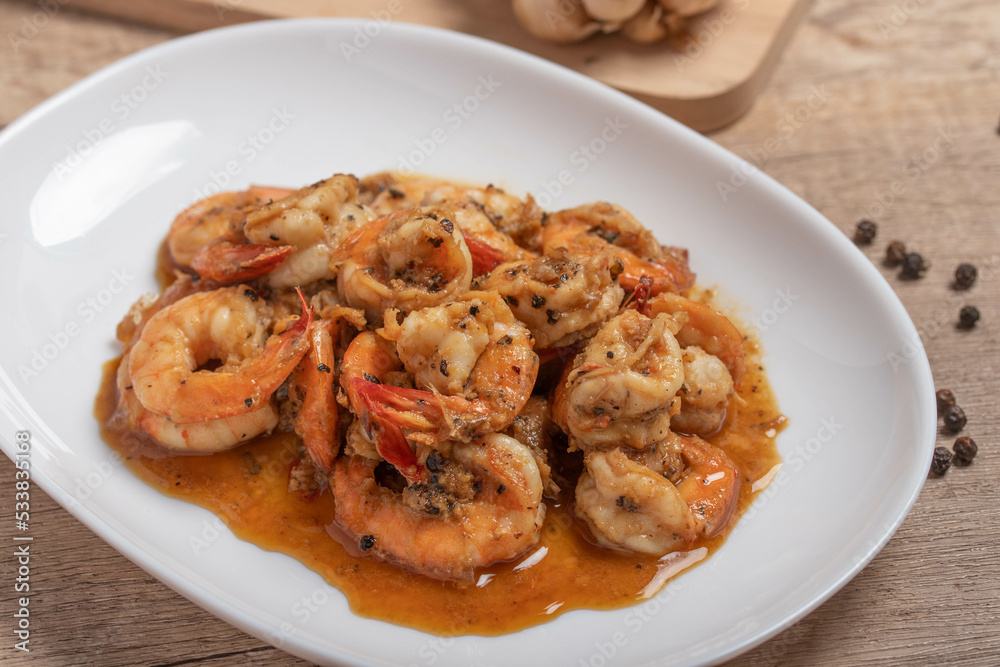 Fried prawns with black pepper and garlic in a white plate