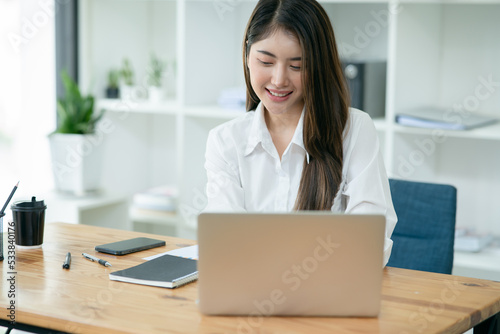 Asian young  woman using laptop on desk working at office 