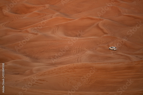 Four wheel drive vehicle carrying tourists on a tour of the sand dunes Dubai