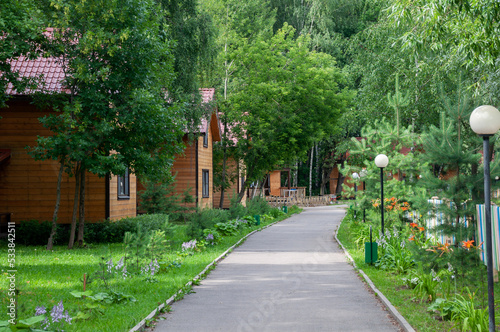 Architectural wooden houses along a walking path in an eco hotel in the middle of a green forest