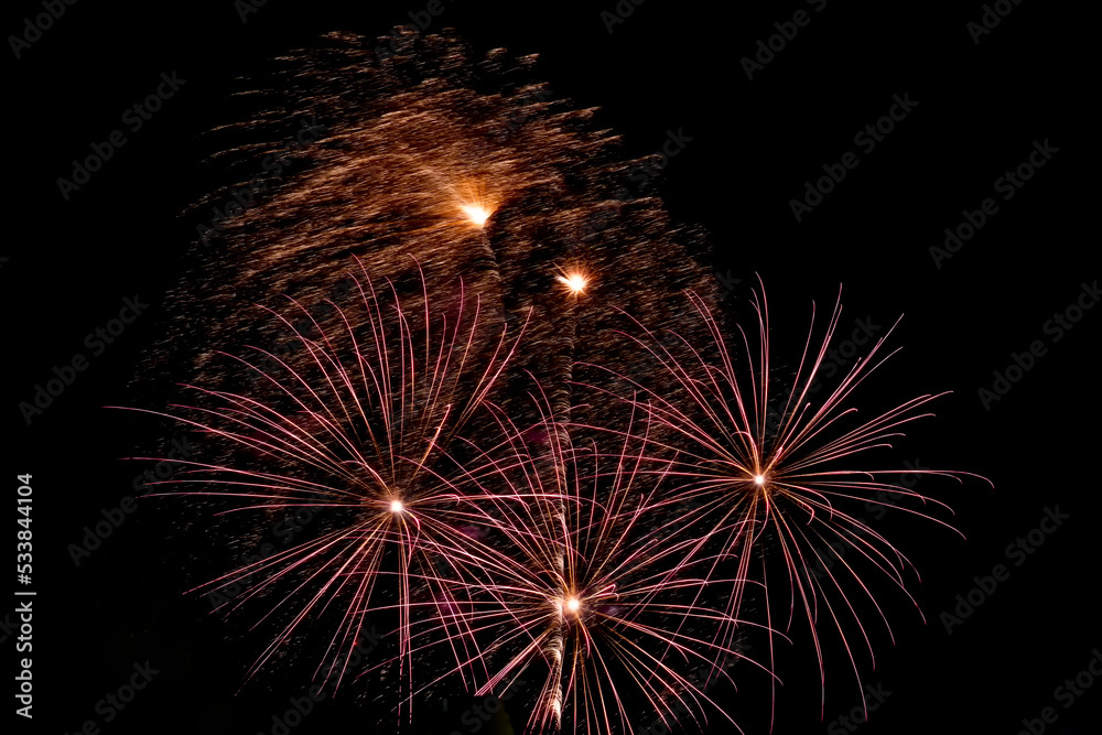 Festive fireworks. Bright beams of exploding pyrotechnics against black night sky.