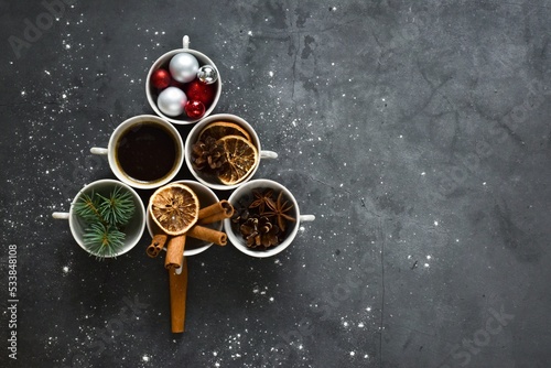 Christmas Tree made of coffee cups the various spices on gray concrete background. Top view, flat lay with copy space. Christmas concept. New Year background. Creative composition