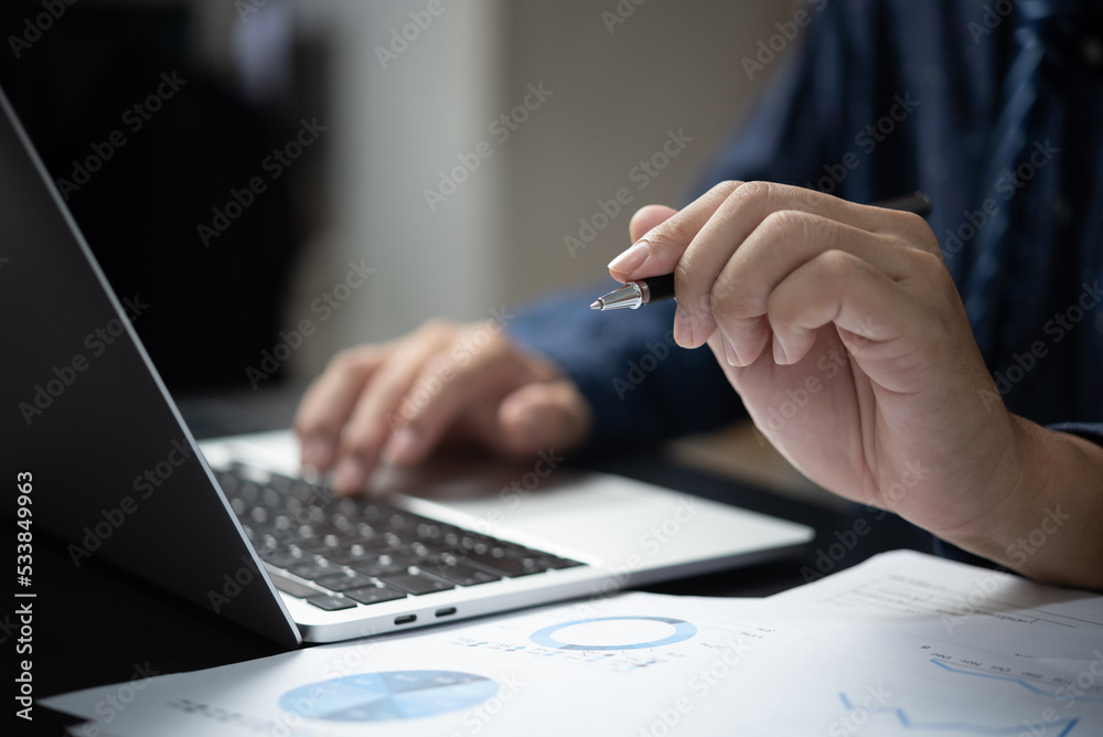 Hand holding pen document graph and chart report finance investment marketing and business accounting analysis plan growth information with computer laptop on desk. Hand holding pen document graph and chart report finance investment marketing and business accounting analysis plan growth information with computer laptop on desk.