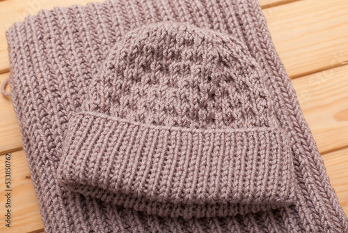 Knitted hat and scarf on grey background.