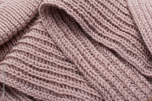 Seamless texture of beige knitted scarf. Repeating hand knitting. The texture of the sweater. Beige Knitted Background.