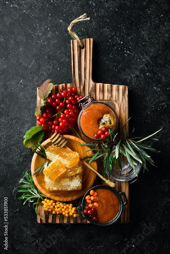 Jam. Viburnum berries and sea buckthorn with honey. Foods with a high content of vitamin C. On a dark background. top view
