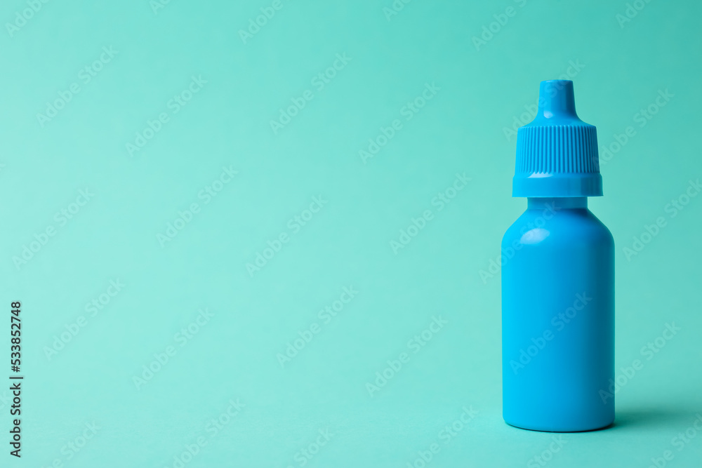 Bottle of medical drops on turquoise background. Space for text Bottle of medical drops on turquoise background. Space for text