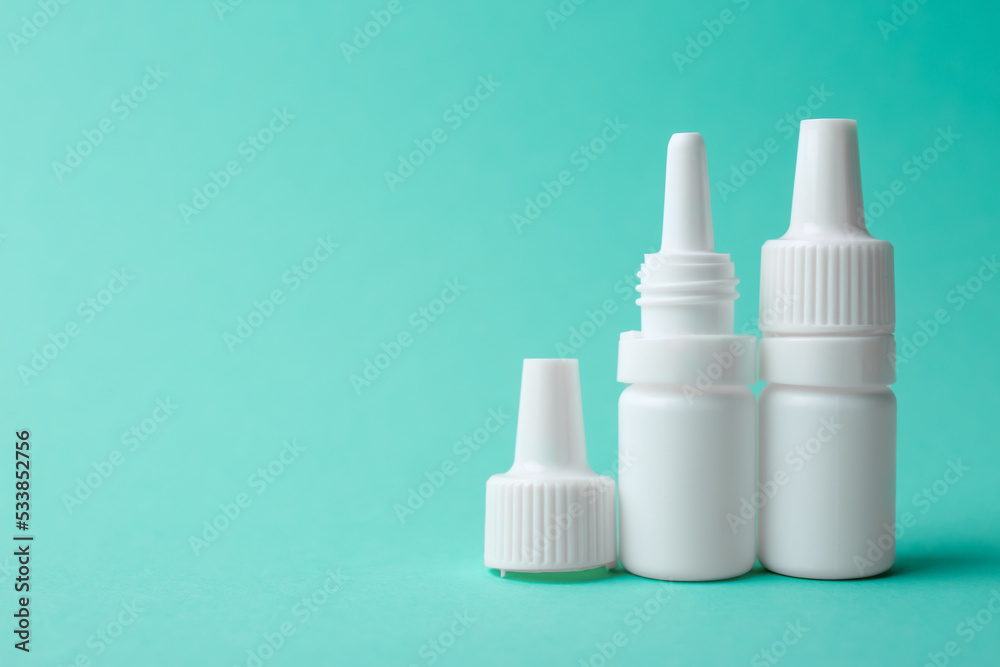 Bottles of medical drops on turquoise background. Space for text Bottles of medical drops on turquoise background. Space for text