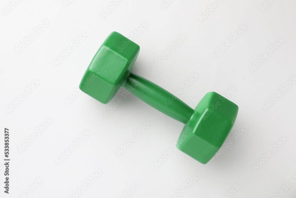 Green vinyl dumbbell on light background, top view Green vinyl dumbbell on light background, top view