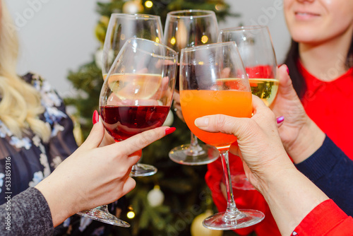 Holidays,celebration and people concept - happy friends having christmas dinner at home drinking alcoholic red wine and champagne.Closeup.