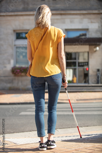 portrait of a blind woman crossing road holding stick photo