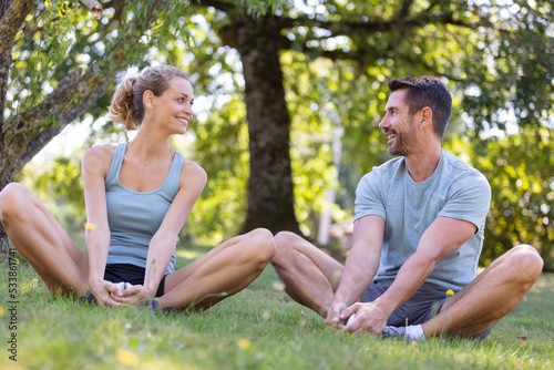 fitness couple stretching outdoors in park