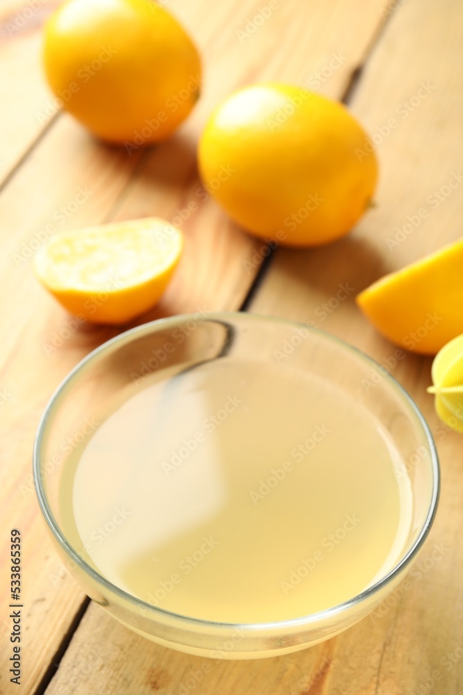 Freshly squeezed lemon juice in bowl on wooden table Freshly squeezed lemon juice in bowl on wooden table