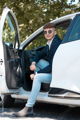 giovane businessman seduto in macchina con una gamba fuori  © Kossonoujeanmichel