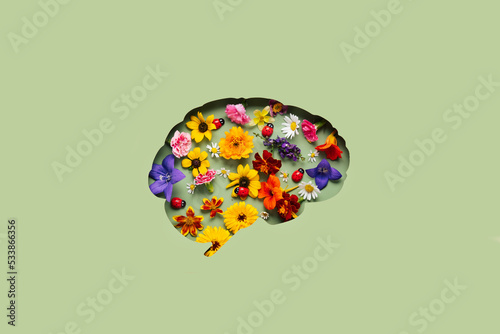 Paper cut brain and flowers on green background. Mental health concept