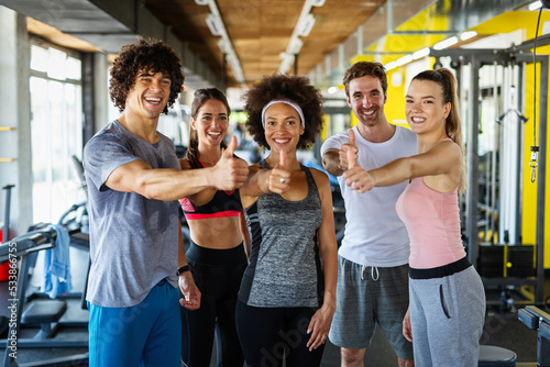 Multiethnic group of people training in a gym. Trainer and sportive fit persons exercising