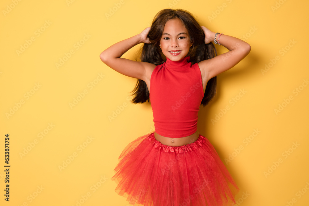 Lovely little girl wearing red clothes having fun with her long hair. Party celebration concept. Lovely little girl wearing red clothes having fun with her long hair. Party celebration concept.