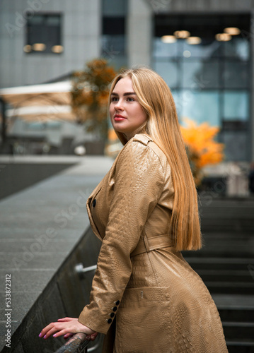 blonde woman in beige coat walking on the street in the Kyiv city in autumn